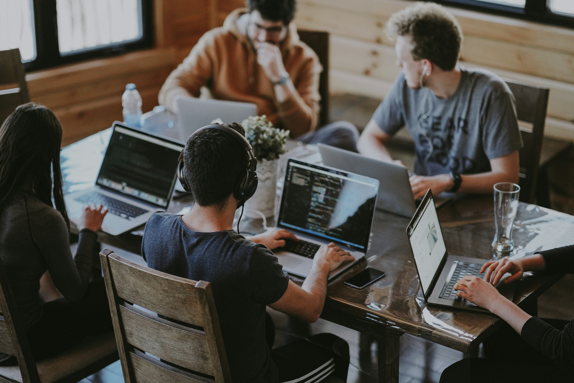 Software engineers collaborating closely around laptops building systems